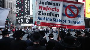 رفع المتظاهرون لافتات كتبت عليها "انتقاد إسرائيل ليس معاداة للسامية"- الأناضول 