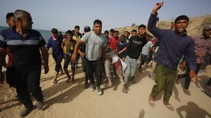شبان يحملون مصابا بقصف للاحتلال- الأناضول