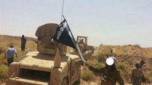 عناصر داعش يزيلون السواتر الترابية على الحدود العراقية السورية وينقلون عربات أمريكية استولوا عليها من الجيش العراقي إلى سورية (أ ف ب)