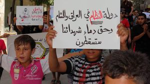 سوريون بإحدى المسيرات يتهمون "داعش" بالتعاون مع النظام السوري - أرشيفية