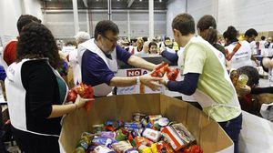متطوعون يجهزون مساعدات غذائية في مستودع في برشلونة - أ ف ب