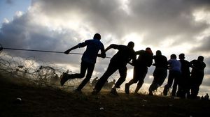 شبان من غزة يزيلون الأسلاك الشائكة التي نصبها الاحتلال- جيتي
