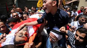 نجل الجديلي خلال بكائه على جثمان والده- وكالة شهاب الفلسطينية