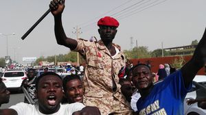 عسكري سوداني محمولا على أكتاف المتظاهرين بعد الإطاحة بالبشير- جيتي
