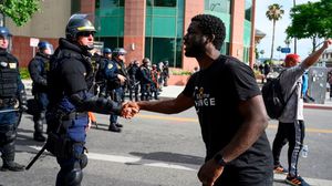 تصافح بعض المتظاهرين مع رجال الشرطة في لوس أنجلوس- جيتي