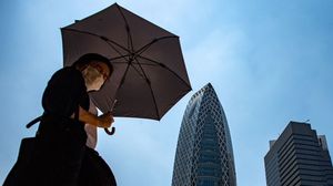 يابانية تحمل مظلة للاحتماء من الشمس الحارقة في طوكيو- جيتي
