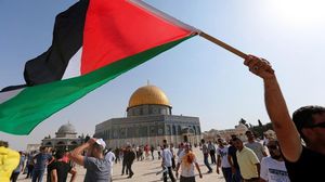 العلم الفلسطيني وخلفه قبة الصخرة المشرفة