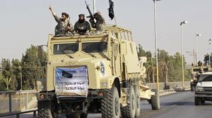 عناصر من داعش ترفع لافتات للخلافة على آليات عسكرية - فيس بوك