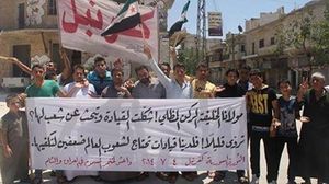 لافتة رفعها متظاهرون الجمعة في بلدة كفرنبل في ريف إدلب - ا ف ب