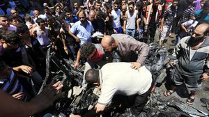 فلسطينيون يجمعون أشلاء الشهداء بعد قصف إسرائيلي لسيارتهم بغزة - الأناضول 