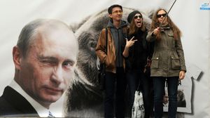 "سيلفي" أمام ملصق للرئيس الروسي فلاديمير بوتين في سانت بطرسبرغ - أ ف ب