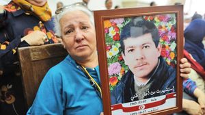 والدة أحد ضحايا حقبة قمع ابن علي ترفع صورته طلبا للعدالة- تسايت