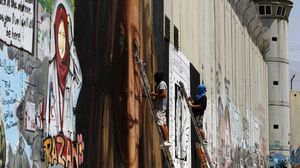 الفنانان الإيطاليان رسما جداريات للتميمي والنجار على جدار الفصل العنصري قرب بيت لحم- جيتي