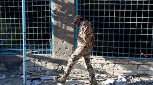 جندي أذري يسير أمام منزل تعرض للقصف من الجيش الأرميني مؤخرا- جيتي