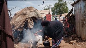 سيدة صومالية تشعل النار أمام خيمتها لإعداد ما توفر من طعام- جيتي