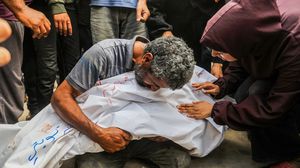 أب فلسطيني يحضن جثمان طفله الشهيد- الأناضول