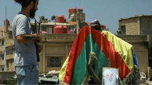 أحد المقاتلين الدروز في السويداء يقف أمام الراية الدينية للطائفة- جيتي