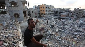 شاب من غزة يقف على ركام منزله - الأناضول