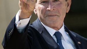 جورج دبليو بوش يرفع ثلاثة أصابع في إشارة إلى حرف "دبليو" - أ ف ب