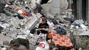 طفل غزي يستخرج كتبه من تحت أنقاض منزله - الأناضول