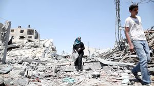 سيدة فلسطينية تتجول بين ركام منزلها في غزة - الأناضول 