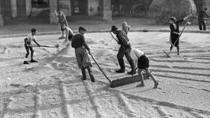 صورة نشرت في أربعينيات القرن الماضي تظهر أطفالا يقومون بتجفيف الحبوب بقرية إيطالية - أ ف ب