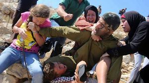 حاول الجندي الإسرائيلي اعتقال الطفل إلا أن والدته وأخريات تمكنّ من تحريره - يوتيوب