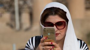 إيرانية تحمل جهاز "آي فون" في طهران- أرشيفية