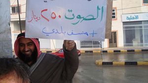 مواطن أردني يرفع لوحة احتجاجية على شراء أصوات الناخبين واستمالتهم بـ"المناسف"- أرشيفية