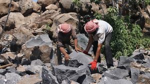 السوريون يعملون على تقطيع الصخور الكبيرة بوسائل تقليدية لإنتاج مسلتزمات البناء - الأناضول