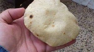 مواطن مصري يمسك برغيف صغير من الخبز بعد تخفيض وزنه- تويتر