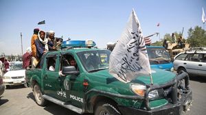 عناصر من طالبان يستقلون عربة للشرطة الأفغانية وسط كابول- جيتي