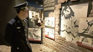 شرطي صيني في متحف أمام صورة لضحايا اغتصاب صينيات على يد القوات الإمبراطورية اليابانية- جيتي