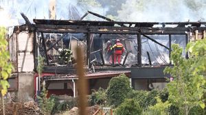 فرق الإطفاء خلال بحثها عن الضحايا بين حطام المنزل المحترق- جيتي