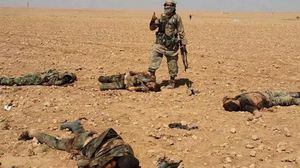 عنصر من داعش يلتقط صورة لجثث جيش النظام السوري في الرقة - تويتر
