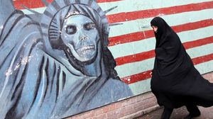 إيرانية تمر أمام جدارية تهاجم أمريكا - (أرشيفية) أ ف ب 