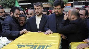 أبادي (الثاني من اليمين) أثناء تشييعه أحد أفراد حزب الله الذين لقوا مصرعهم بتفجير السفارة 2013 - أ ف ب