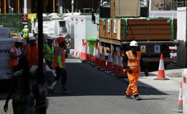 عمال بناء يتجمعون في الظل في موقع بناء بوسط العاصمة البريطانية لندن في 24 حزيران/يونيو 2026