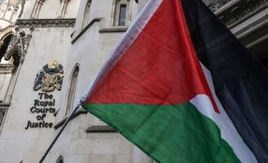 متظاهرون يرفعون العلم الفلسطيني خارج مقر المحاكم الملكية البريطانية في وسط لندن في 26 تشرين الثاني/نوفمبر 2025