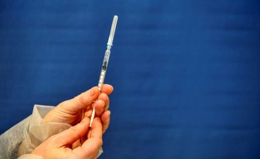 ممرضة تحمل محقنة تحتوي على لقاح كوفيد مخصص لشخص مسن في 20 كانون الثاني/يناير 2021 في مركز للتطعيم بمدينة كيمبر في غرب فرنسا