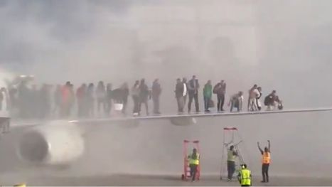 ركاب طائرة يلجأون إلى جناحها بعد اشتعال النيران بمحركها ...