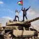 فلسطينيون يعتلون دبابة ميركافا مدمرة على السياج الفاصل مع غزة- الأناضول