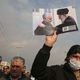 رجل يحمل صورة خامنئي مع سليماني في مظاهرة في طهران - جيتي أ ف ب