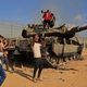 فلسطينيون يعتلون دبابة مدمرة للاحتلال بعد انطلاق عملية طوفان الأقصى- جيتي