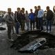 عراقيون يتجمعون أمام حفرة تسببت بها السيارة المفخخة- أ ف ب