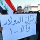 عراقي يرفع لافتة احتجاج خلال تظاهرة على أزمة الدولار في بغداد- الأناضول