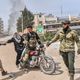 مقاتلون من المعارضة السورية يقومون بإخلاء مدنيين خلال المعارك وسط عفرين- جيتي