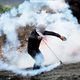 فلسطيني يرمي قنبلة غاز على قوات الاحتلال- الأناضول