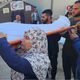 فلسطينية تحمل ابنها الشهيد على كتفها قبل دفنه- الأناضول