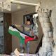 شاب فلسطيني في مخيم جباليا يرفع العلم على ركام منزله بعد انسحاب الاحتلال- الأناضول